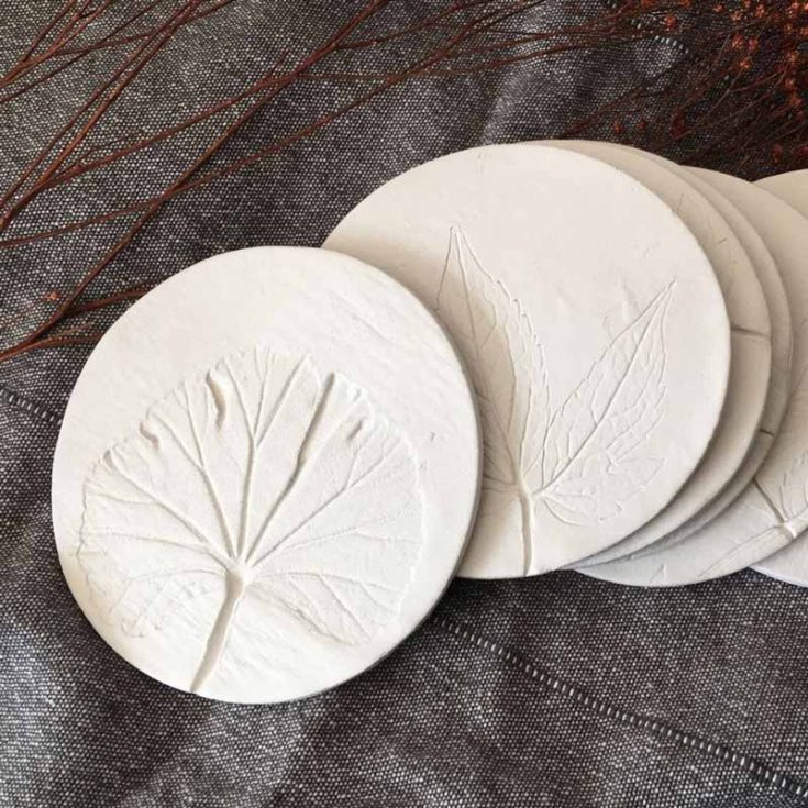 Nature lovers are sure to love these botanical-inspired clay coasters. By imprinting a leaf onto the air-dry clay before it dries, you can create these coasters that bring a touch of natural elegance to your home.