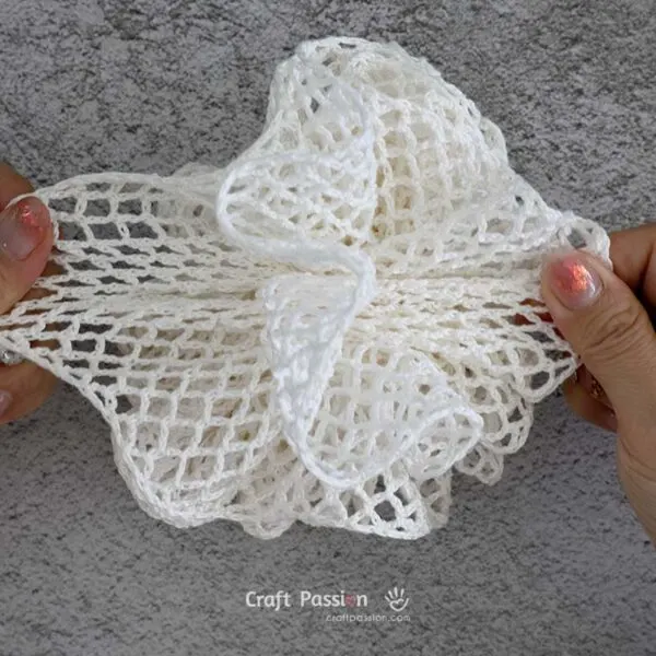 crochet washcloth pouf 10 Once cinched, gently tug the layers apart with your fingers to fluff up the loofah.