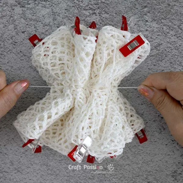crochet washcloth pouf 9 Gently pull the thread to gather the fabric and cinch it into a loofah shape.