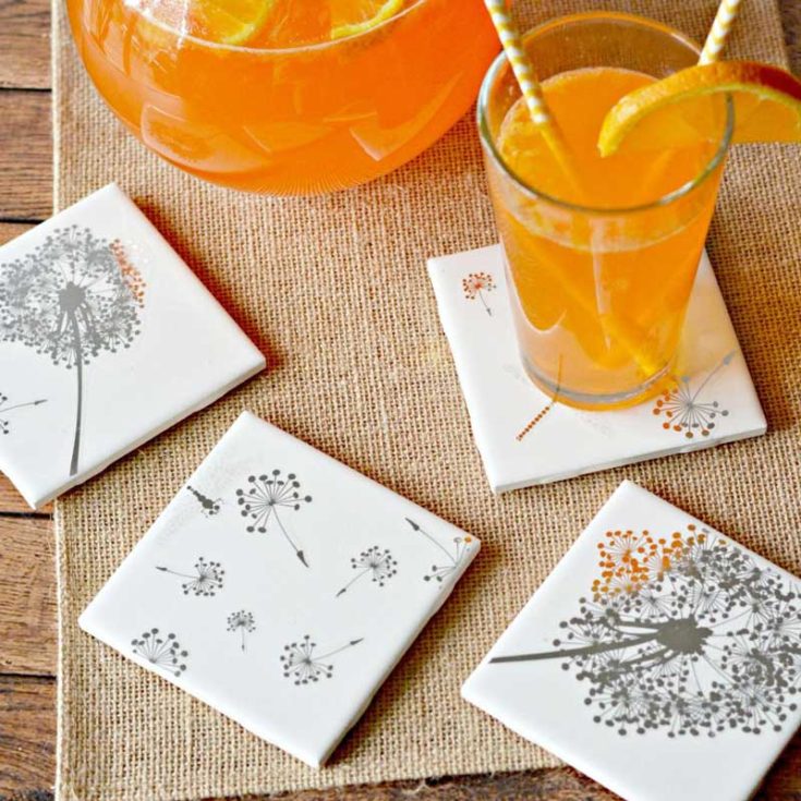 Learn how to make coasters that fit your home aesthetic. This gorgeous design adds fresh air and tranquility to your space with tile coasters adorned with delicate dandelion prints created using peel-and-stick wall decor!