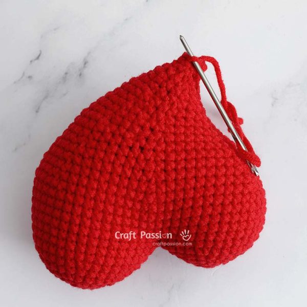 Finished whimsical curvy heart amigurumi after closing the tip