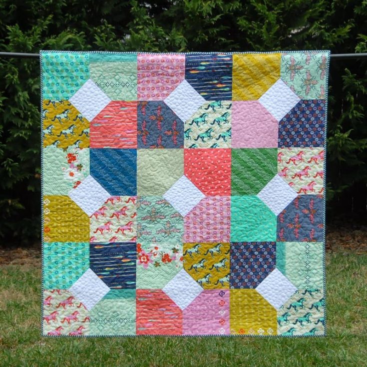 Have a look at this gorgeous quilt called the Layers of Charm! This inviting quilt piece uses the Mustang fabric collection by Melody Miller, which has various colors and prints in the layer cake bundle that give this quilt a fun, scrappy look. The finished size of this quilt measures 57.5&rdquo; x 57.5&rdquo;, resulting in a generous lap-sized quilt. Learn how to make it by clicking the link below to access the tutorial.