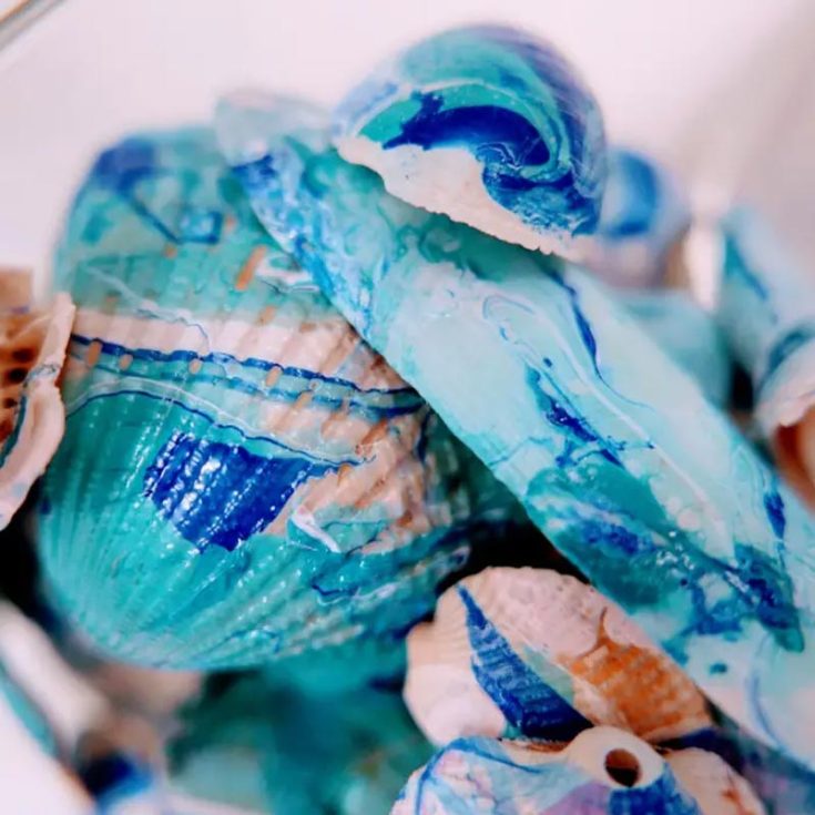 Try painting seashells with a marbling technique using nail polish for a fun and creative family activity! The results are super cool and add a unique twist to your seashell collection. It's a craft everyone can enjoy together!