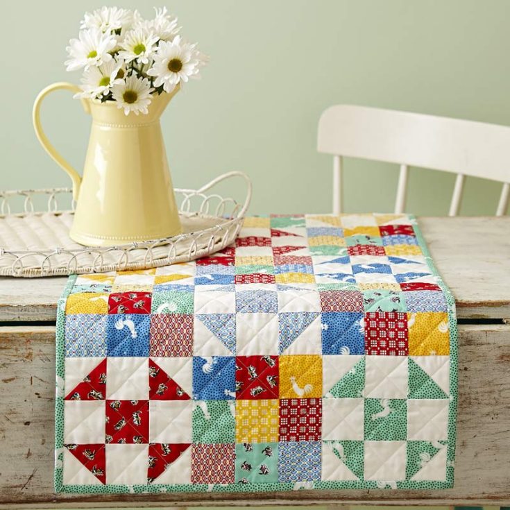 Learn how to make a table runner with this easy-to-follow tutorial! It features lovely bright colors using precut print strips and solid whites. It adds a beautiful contrasting hue to the vibrant colors of the quilt table runner!&nbsp; Table runner size: 18 &frac12;&rdquo; x 42 &frac12;&rdquo;