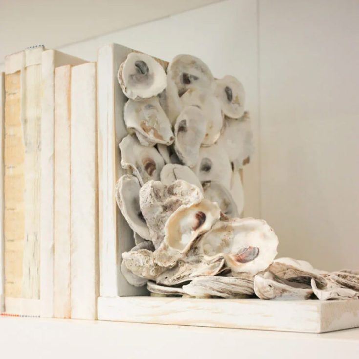 Give your bookshelf a splash of ocean charm by crafting these stylish oyster shell bookends. It brings a beachy vibe right to your home and makes a fun, functional addition to your decor! Not only do they look fabulous, but they also keep your favorite books perfectly in place.