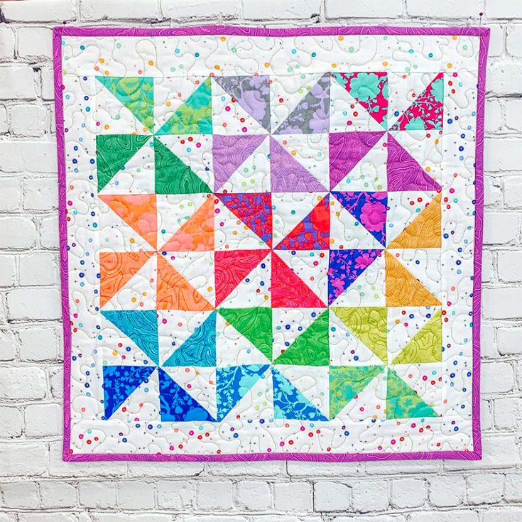 Once you've mastered the half-square triangle quilt block, this pinwheel quilt pattern from The Lucy Bird would be super easy for you! Just piece together a four-patch quilt block with the HSTs and you'll have this modern quilt!