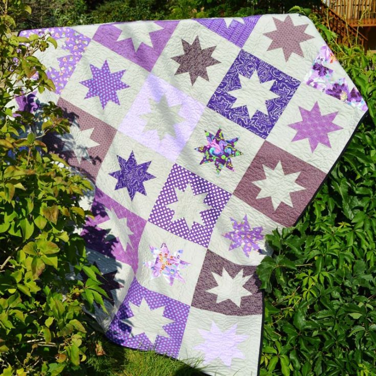 This has to be, by far, our favorite piece of all time. The soft and vibrant hues of purple with various star blocks pull the piece together so beautifully. It&rsquo;s a beginner-friendly design that all should get their hands on. It offers clear instructions on how to create this sparkling masterpiece. The finished size is 67&rdquo; x 81&rdquo;.