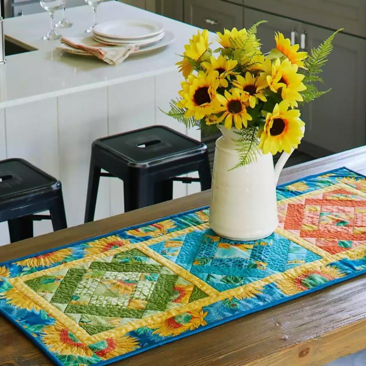 This quilt project adds a touch of floral vibes to your living space! This table runner features lovely scraps in vibrant colors with sunflower prints that bring spring to your home decor. Isn't it cute? Table runner size: 19" x 42"&nbsp;