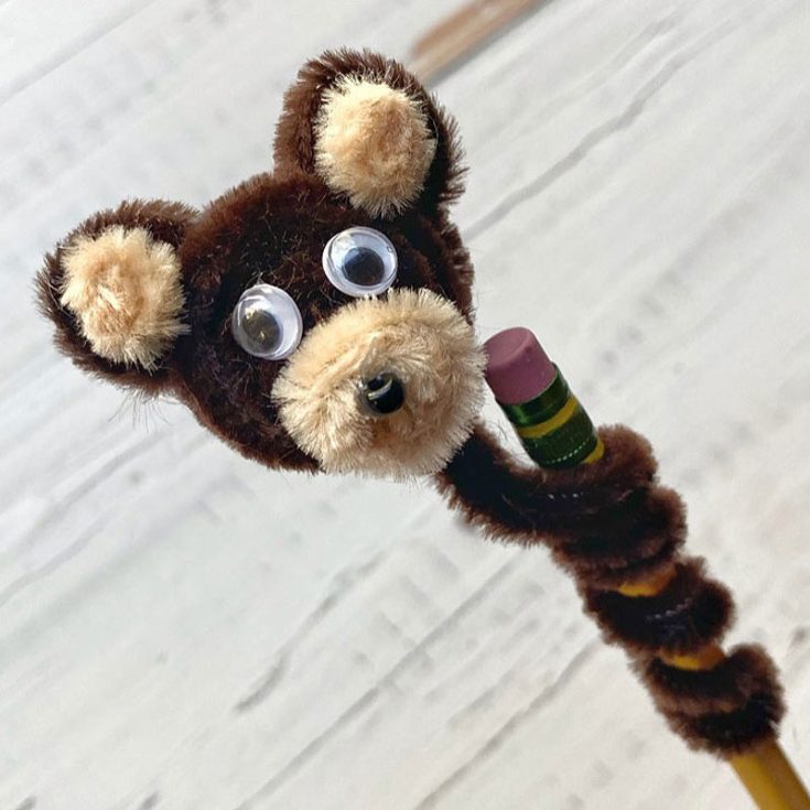 Add a touch of whimsy to your school supplies with this cute teddy pencil topper crafted from some brown pipe cleaners and googly eyes. These quirky creations are sure to make homework a little more fun.
