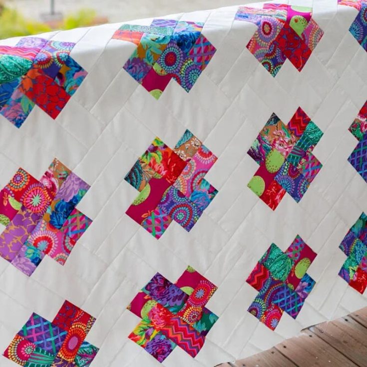 Get into the romantic vibe with this sweet Kisses quilt pattern! If you want to quilt a cuddly blanket to share the love with that special someone, follow the step-by-step guide today! Simply prepare half a jelly roll bundle of print fabric and a jelly roll of solid fabric for the background. Size: 56&rsquo;&rsquo; x 68&rsquo;&rsquo;