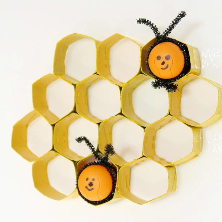 Celebrate the sweetness of nature with these DIY honeycomb decorations made from toilet paper rolls! Cut the rolls into sections, bend them into hexagons, and arrange them in a honeycomb pattern, painting them in golden hues. Display them as wall art with little bees made out of recycled Kinder eggs.