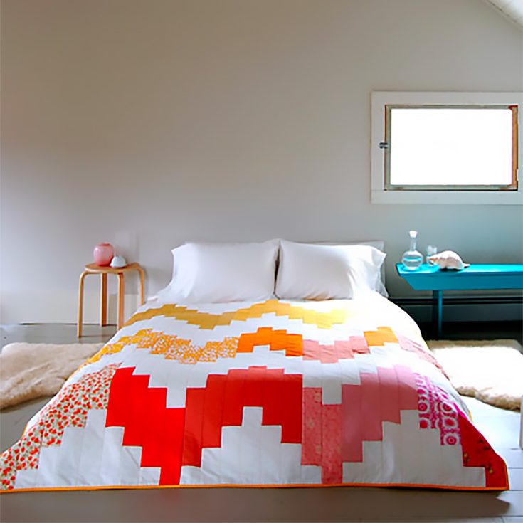 For this chic wedding quilt, you'll be arranging 25 vertical strips into a zig-zag pattern! To give it this burst of vibrant color, prepare yourself a spectrum of colored fabrics to incorporate into your quilt!