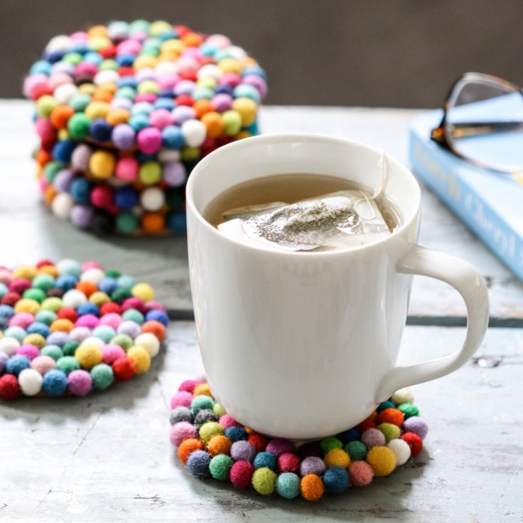 These fun wool-felt ball coasters will surely bring your coffee table a cheerful touch. With a quick trip to the craft store, you can easily craft these delightful DIY coasters with felt balls glued onto cork coasters.
